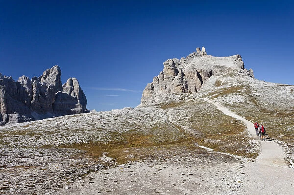 Hikers ascending Mt Paternkofel or Paterno, Tre Cime di Lavaredo mountain group and Mt Paternkofel or Paterno in the back, Sexten, Sesto, Hochpustertal or Alta Pusteria, Dolomites, South Tyrol, Europe