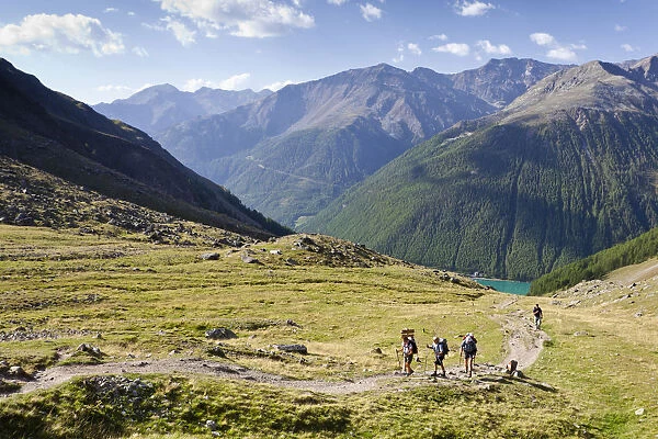 Hikers ascending to the Similaun Hut, Schnalstal Valley through Tisental Valley, with th Vernagt Reservoir below, Alto Adige, Italy, Europe
