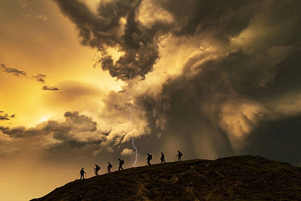 Hikers on the storm at sunset, Catbells Mountain, Lake District. UK