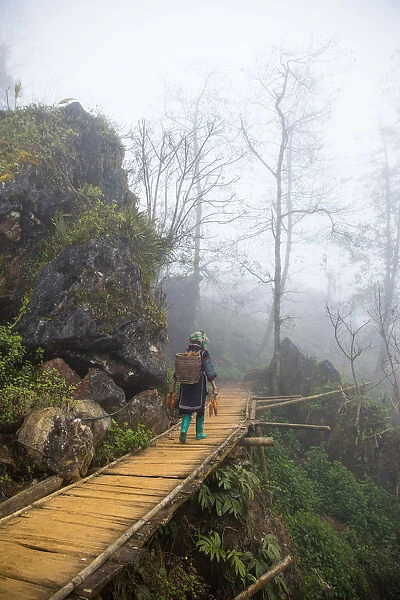 Hmong minority steps on wood staircase in Sa Pa