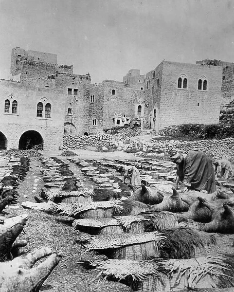 Holy Land. 25th June 1927: A tanner of Hebron preparing goat skins for carrying water