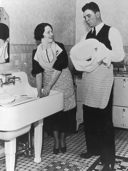 Home Help. A boxer helps his wife with the washing up, circa 1928