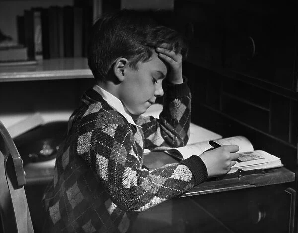 Homework. A little boy reading his homework, circa 1950