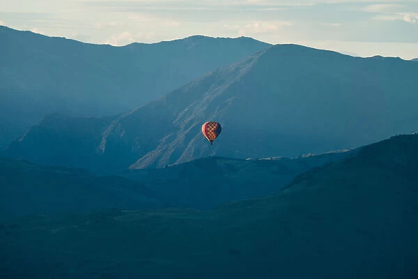 Hot air balloon flying over mountain range at Queenstown