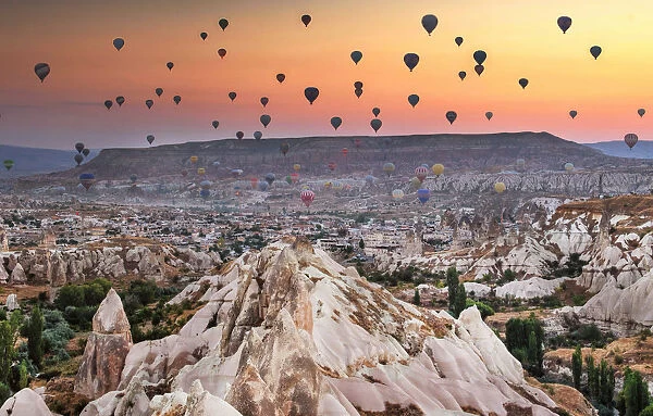 Hot air balloon flying over rock landscape at Capp