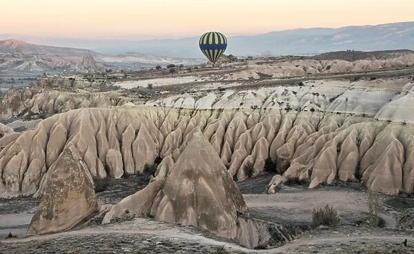 Hot air balloon flying over rock landscape at Cappadocia Turkey