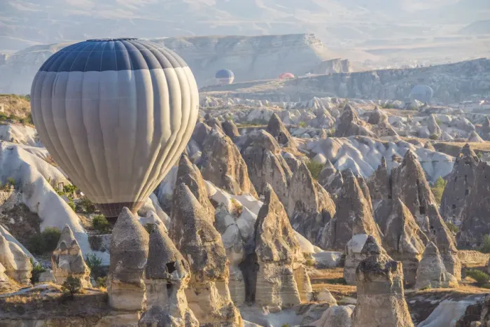 Framed Print : Hot air balloon flying over rock landscape at Cappadocia Turkey