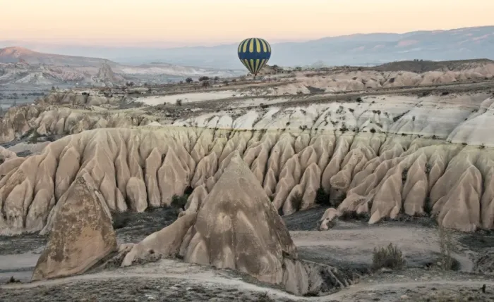 Framed Print : Hot air balloon flying over rock landscape at Cappadocia Turkey