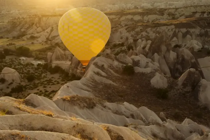 Framed Print : Hot air balloon flying over rock landscape at Cappadocia Turkey