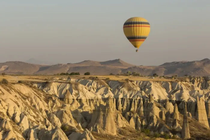 Framed Print : Hot air balloon flying over rock landscape at Cappadocia Turkey Framed Print : Hot air balloon flying over rock landscape at Cappadocia Turkey