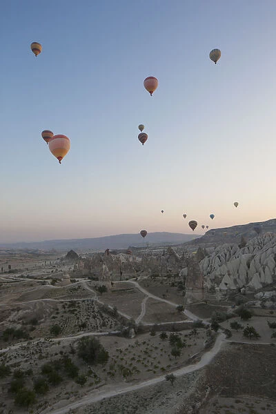 Hot air balloons flying over rocky landscape