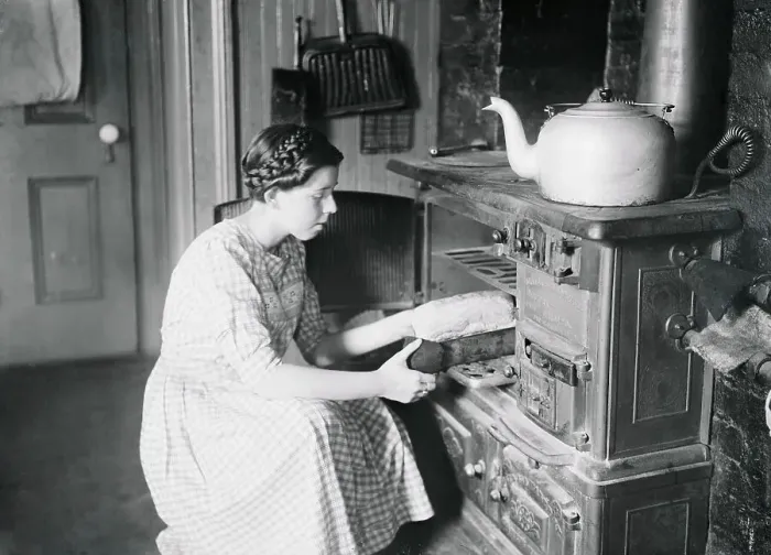 Framed Print : Housekeeper Putting Food in Oven Framed Print : Housekeeper Putting Food in Oven
