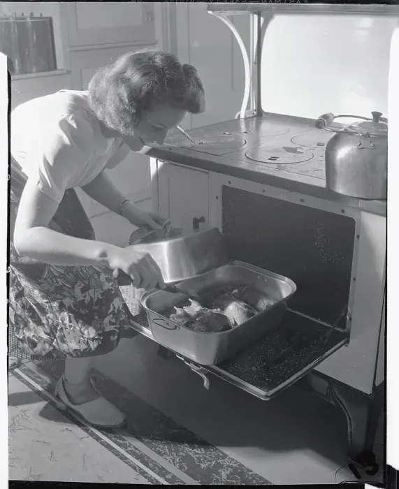Framed Print : Housewife Checking on Chicken in Oven Framed Print : Housewife Checking on Chicken in Oven
