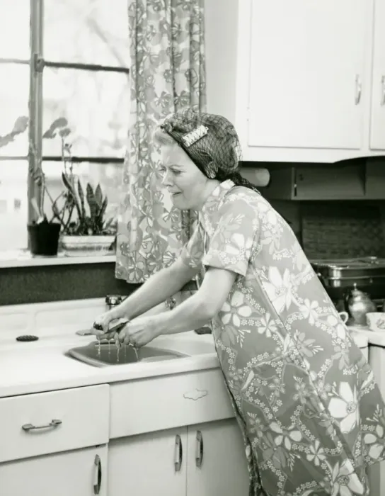 Framed Print : Housewife doing dishes at kitchen sink, (B&W)