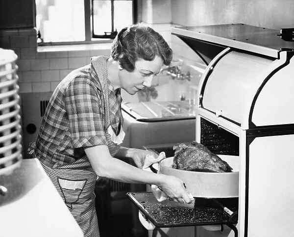 Housewife removing turkey from oven, (B&W)