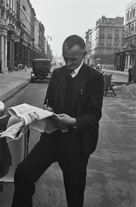 Framed Print : Hunted. A film crew member takes time out to complete the newspaper crossword Framed Print : Hunted. A film crew member takes time out to complete the newspaper crossword