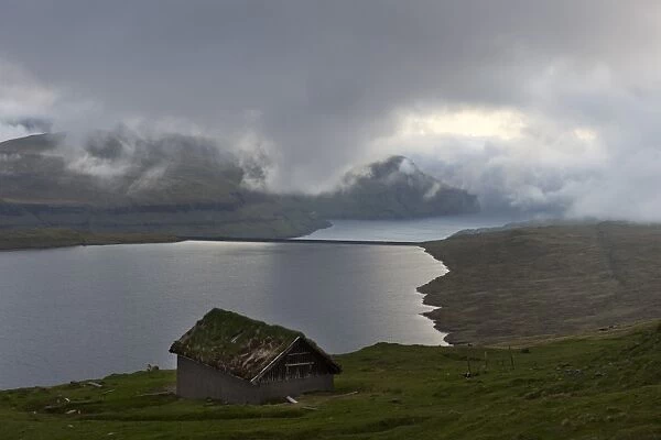 Hut at Eidisvatn lake, low clouds, Eysturoy, Faroe Islands, Denmark
