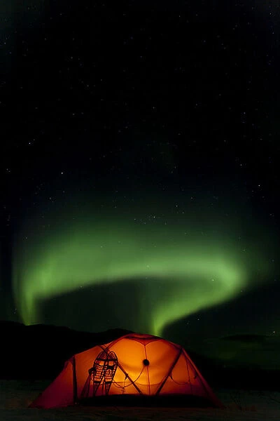 Illuminated expedition tent and traditional wooden snow shoes, Northern or Polar Lights, Aurora Borealis, green, near Whitehorse, Yukon Territory, Canada