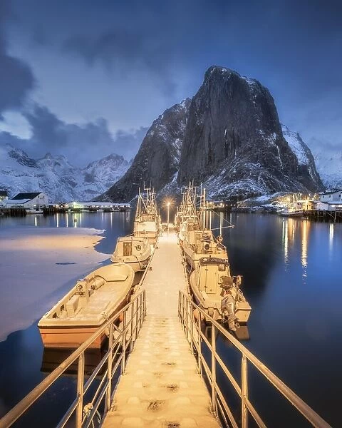 Illuminated landing stage, jetty at the harbour of the fishing village Hamnoy Polar Night