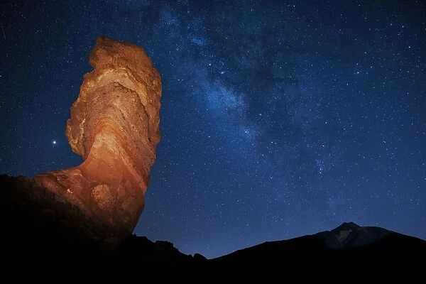 Illuminated Roque Cinchado in front of Pico del Teide with starry sky, Milky Way