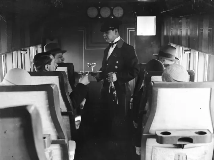 Framed Print : In-Flight. A flight attendant serves drinks to passengers on a French Airliner