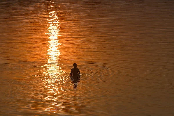 India, Goa, swimmer silhouetted in water, elevated veiw