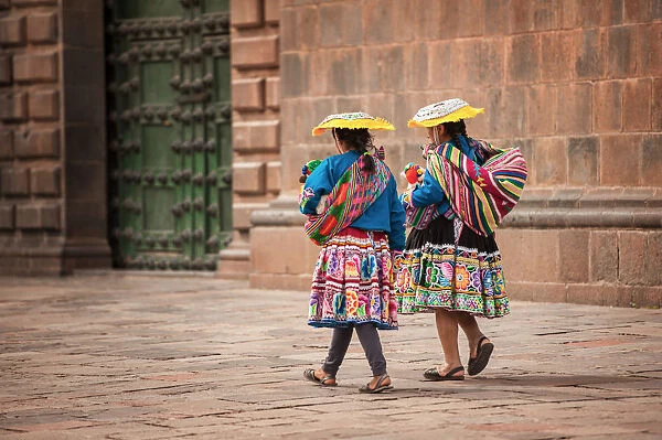 Two indigenous women walking in the city square of Cusco, Peru