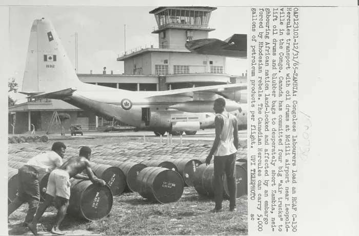 Framed Print : Industry Workers Moving Cannisters on Airport Grounds Framed Print : Industry Workers Moving Cannisters on Airport Grounds