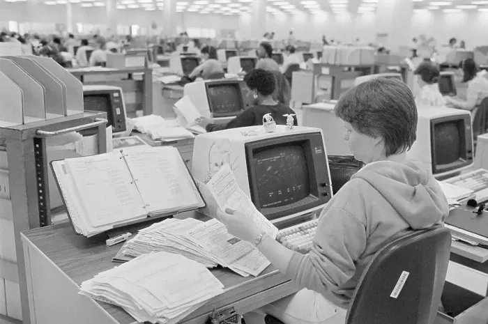 Framed Print : IRS Worker Checks Through Pile Of Forms