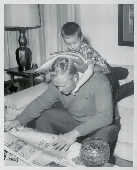 Framed Print : Jack Nicklaus Reading Newspaper with Son on His Back Framed Print : Jack Nicklaus Reading Newspaper with Son on His Back