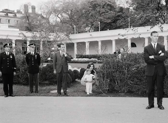 Framed Print : Jacqueline Bouvier Kennedy Stooping in Garden with John Fitzgerald Kennedy Jr