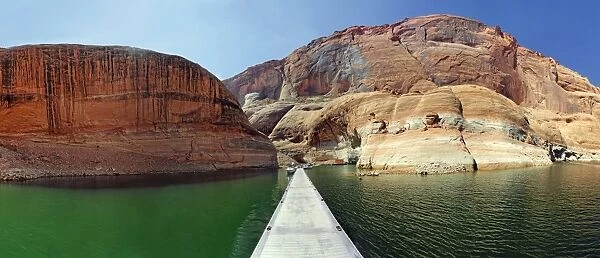 Jetty and red Navajo sandstone cliffs, rock formations rising from Lake Powell, Page, Arizona, USA