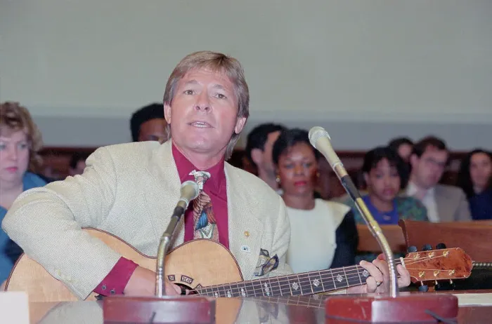 Framed Print : John Denver Signing During Hearing