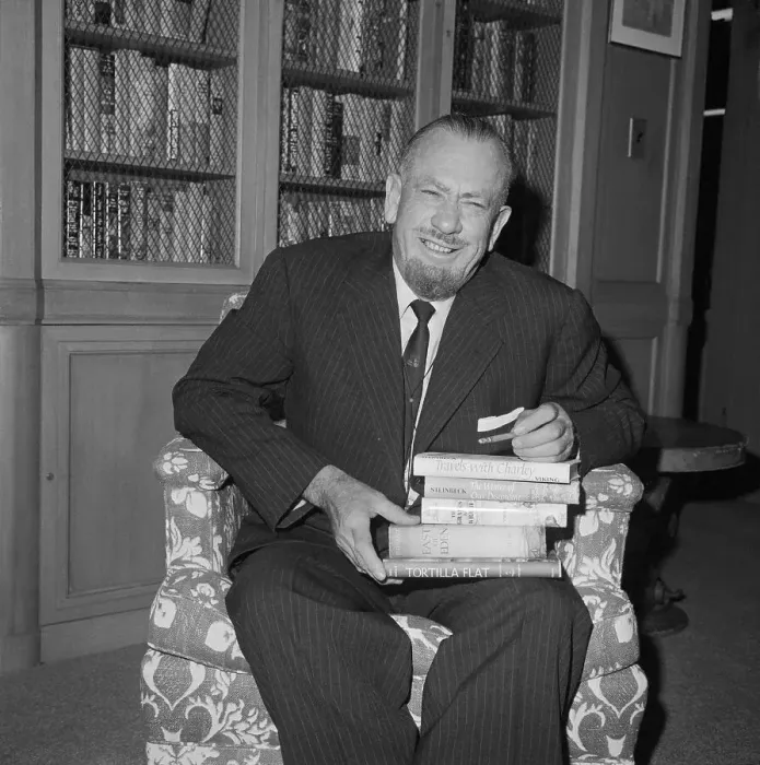Framed Print : John Steinbeck Sitting and Holding Stack of Books Framed Print : John Steinbeck Sitting and Holding Stack of Books