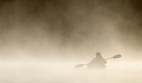 Kayaking photographer in the fog
