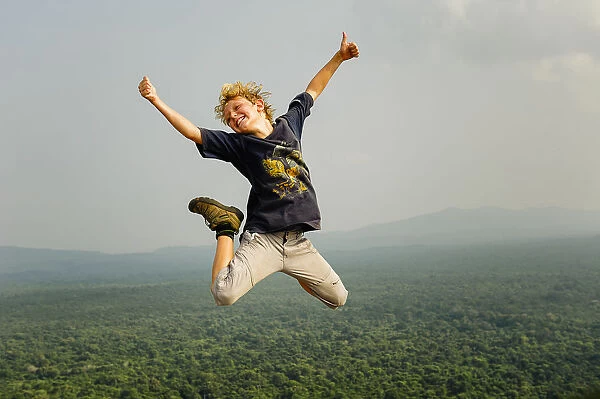 A kid jumping above the forest