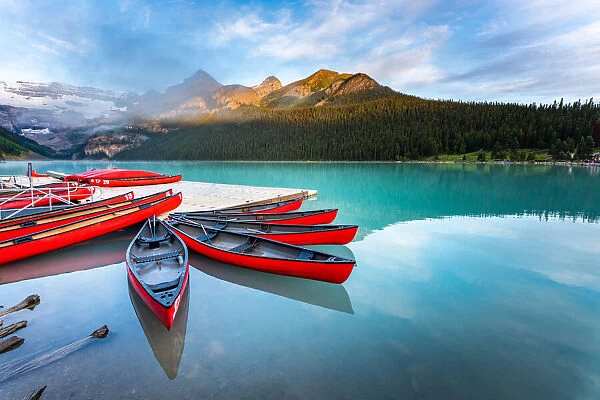 Lake Louise, canoe and kayak on calm water at sunrise. Banff, Canadian Rockies, Canada