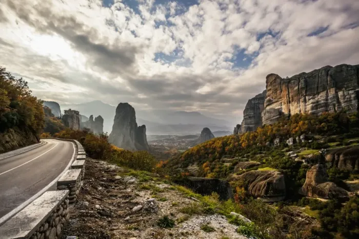 Framed Print : Landscape of rugged cliffs, road, autumn foliage and Monastery Rousanou in the distance Framed Print : Landscape of rugged cliffs, road, autumn foliage and Monastery Rousanou in the distance