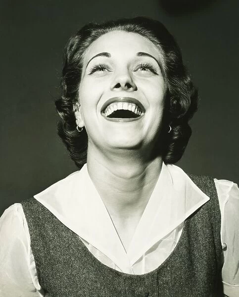 Laughing woman posing in studio, (B&W), portrait