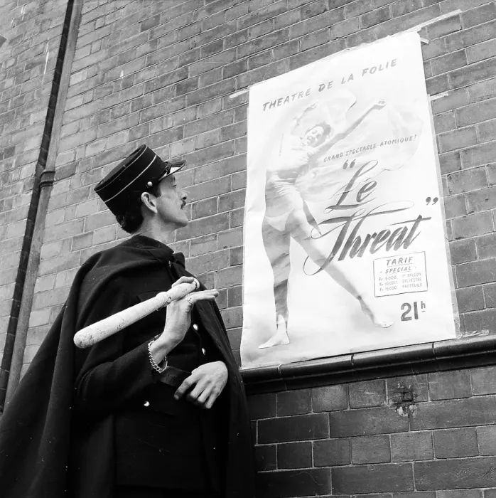 Framed Print : Le Threat. 3rd July 1954: A French official looking at a poster for a performance Framed Print : Le Threat. 3rd July 1954: A French official looking at a poster for a performance