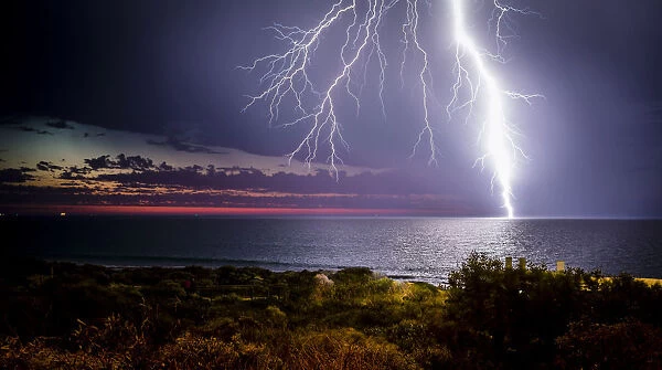 Lightning Storm. Lightning strikes over the ocean at sunset
