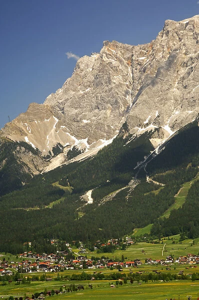 The limestone wall of Mt. Zugspitze with the top station of the Tyrolean Zugspitze Cable Cartowers above the valley town of Ehrwald, Wettersteingebirge range, Tyrol, Austria, Europe