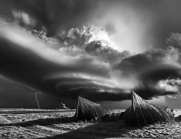 Lindisfarne Castle in Northumberland with a monster supercell thunderstorm in dramatic black and white