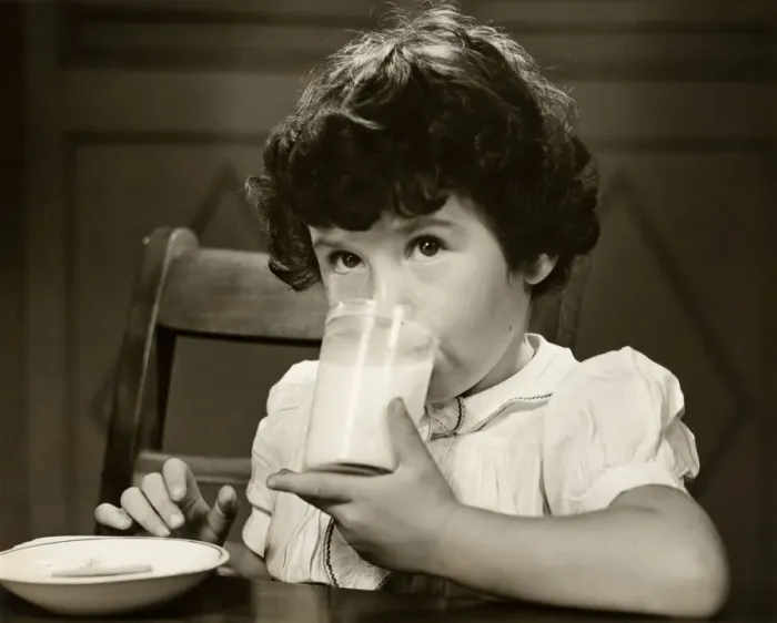 Framed Print : Little girl drinking a glass of milk at table Framed Print : Little girl drinking a glass of milk at table