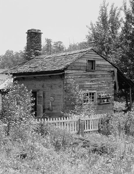 Log cabin. UNITED STATES - CIRCA 1930s: Rustic log cabin in wilderness
