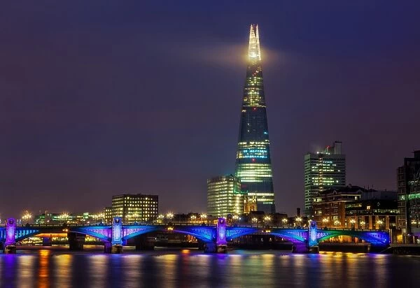 London. towers over the colourful Southwark Bridge