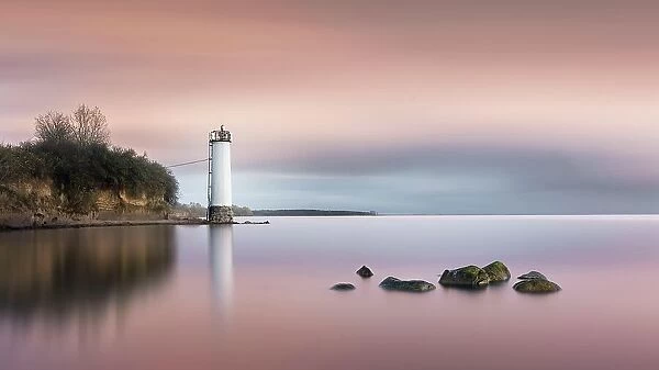 Long exposure of a colourful sunset behind the abandoned lighthouse on the Baltic Sea coast in Maltzien on Ruegen, Germany, Europe