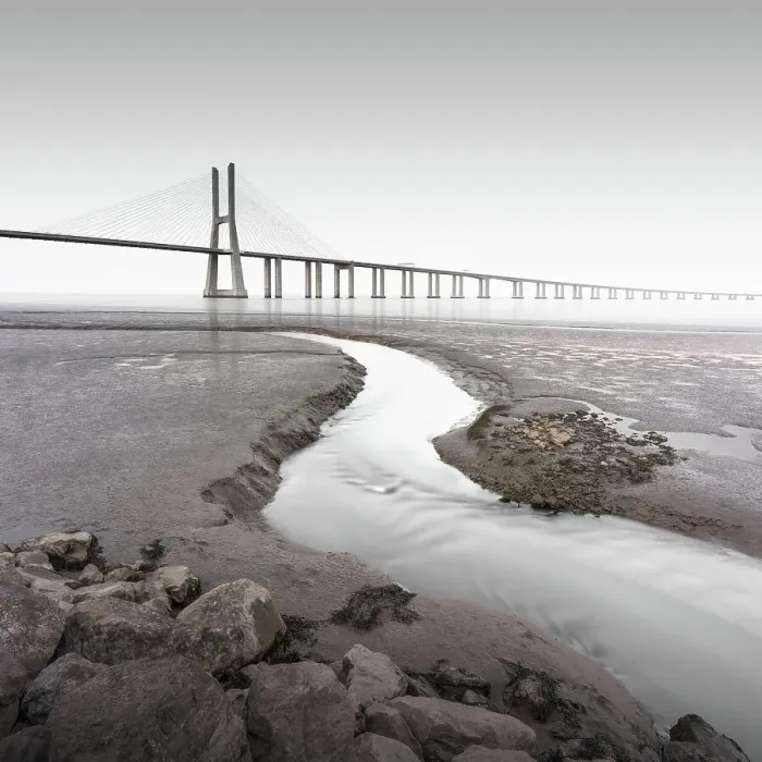 Framed Print : Long exposure of the famous bridge Ponte Vasco da Gama at low tide on the river Tejo with a small water tributary in Lisbon, Portugal