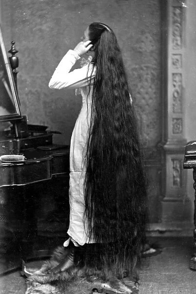 Long Hair. circa 1890: Miss Milo standing in front of a dressing-table