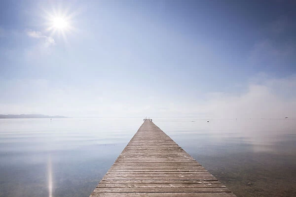 Very long jetty on Chiemsee Lake with high fog and sun near Seebruck, Bavaria, Germany, Europe, PublicGround